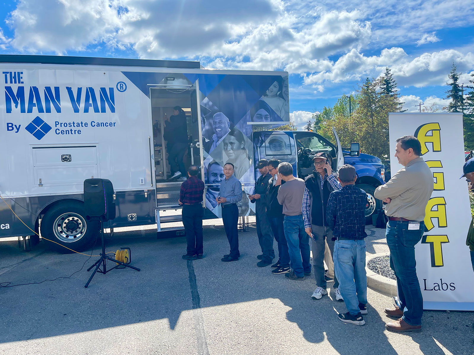 People lined up outside the MAN VAN® mobile clinic at an AGAT Labs event.