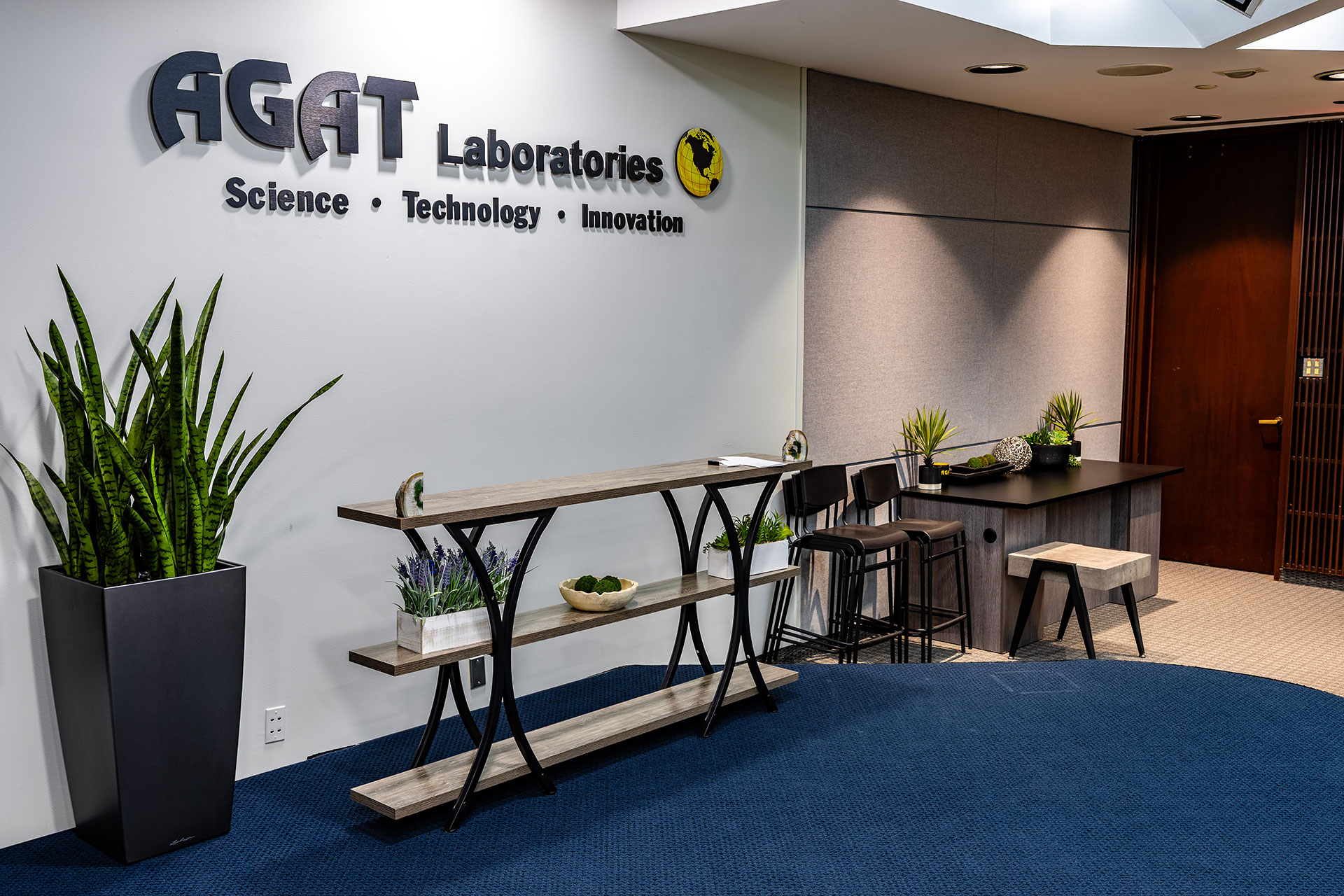 The Michael DeSanti Centre for Excellence auditorium showing the AGAT Laboratories logo wall and seating area.