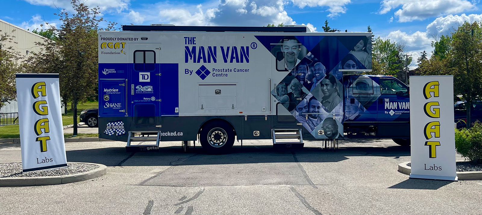 Side view of the MAN VAN® mobile clinic with AGAT Labs banners.