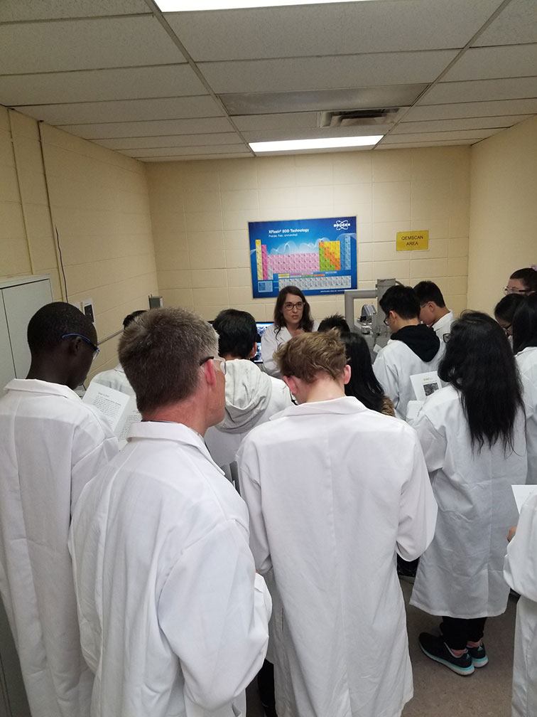 students-on-tour-at-agat-labs-with-periodic-table-on-wall